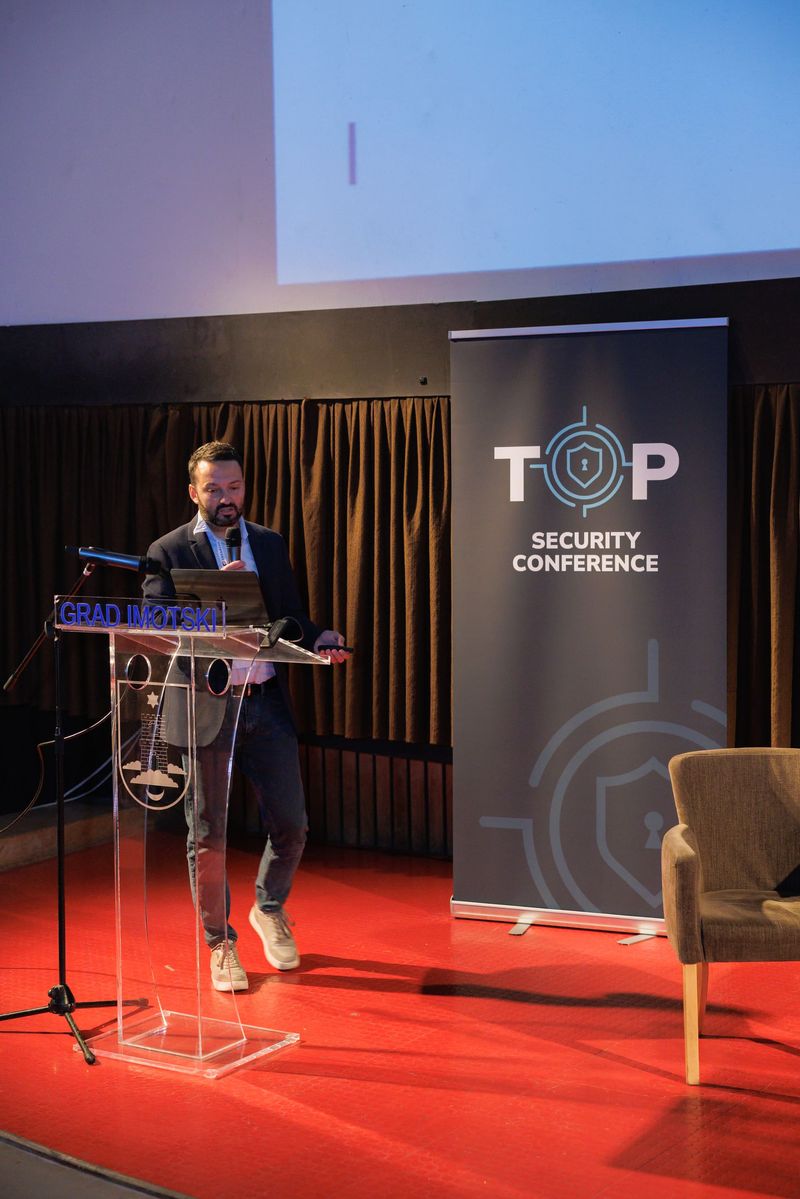 Predavanje za govornicom uz TOP roll-up na konferenciji 2026.